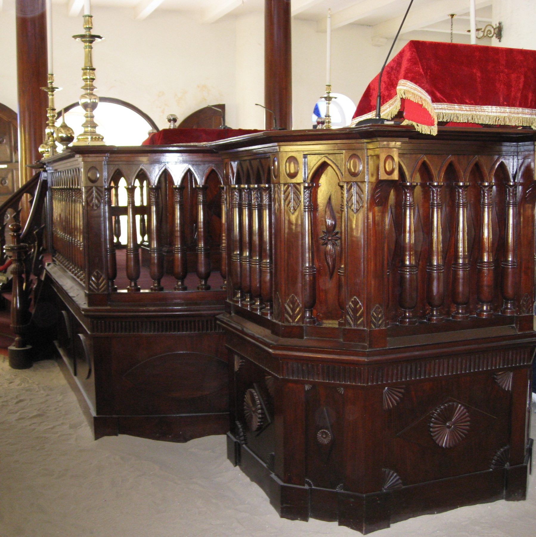 Interior of the Mikvé Israel-Emanuel synagogue in Willemstad, Curaçao, with the dark mahogany bimah and benches set above its famous white sand floor
